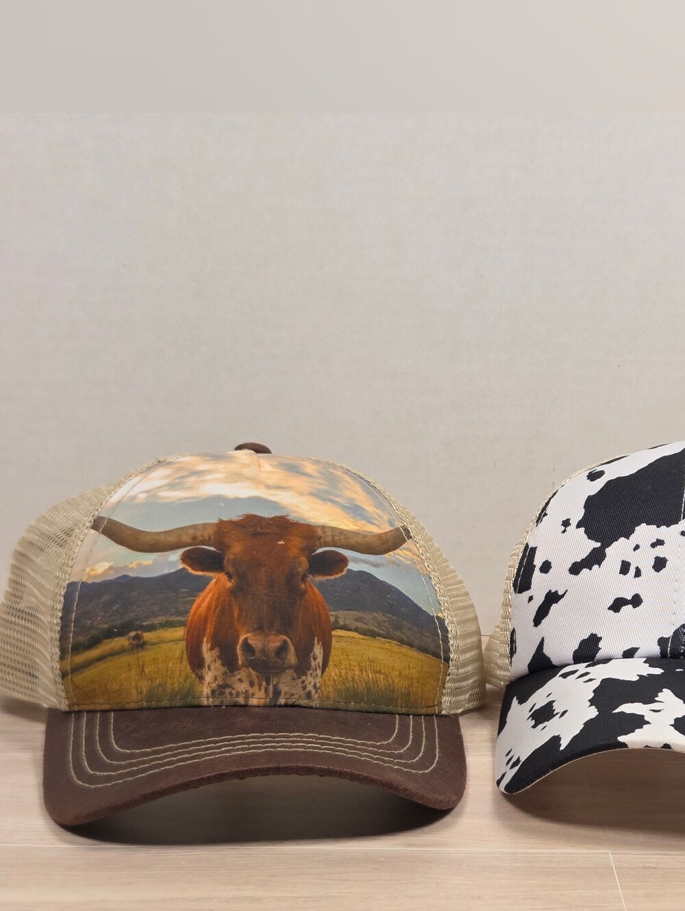 two casual mesh-back trucker hats with western-themed prints